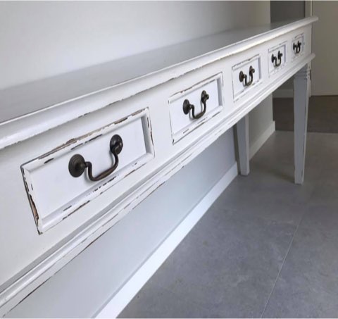 White distressed-finish hall table with five drawers and brass handles